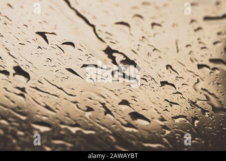 Gocce di pioggia sul finestrino si chiudono. Gocce di pioggia sulla macro di vetro. Gocce d'acqua che cadono sul finestrino. Giorno di pioggia. Vetro bagnato. Gocce di pioggia che scendono verso il basso Foto Stock