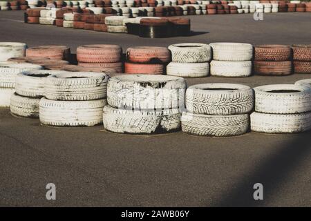 Barriera di sicurezza pista da gara. Pista asfalto con gomme rosse e bianche. Cataste colorate. Pista Karting Foto Stock