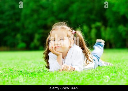 Immagine di un bambino sdraiato sull'erba nel parco Foto Stock