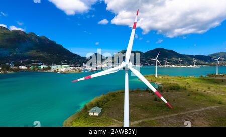 Veduta aerea: Turbine eoliche offshore alle Seychelles, Mahe Victoria Foto Stock