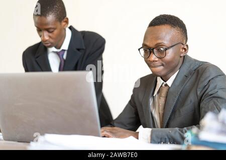 CEO e Collaboratore di African Descent che lavorano su laptop Foto Stock