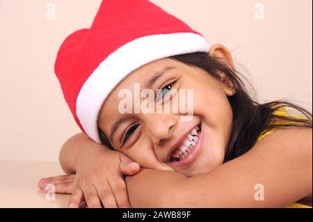 Mumbai, Maharashtra, India - Asia, 29 dicembre 2014 - ragazza piccola cute indiana Felice in cappello rosso di Babbo Natale Che Celebra il festival di Natale Foto Stock