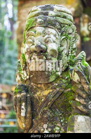 Un'antica scultura in pietra presso il Tempio di Bukit Sari nella Foresta della Scimmia Santa di Sangeh a Bali. Foto Stock