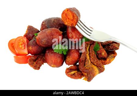 Gruppo di polpette di chorizo speziate con pomodori secchi e freschi isolati su sfondo bianco Foto Stock