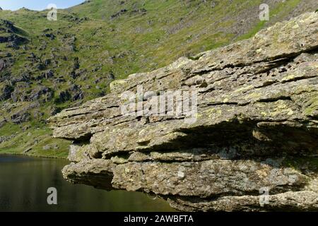 Affioramento Di Roccia, Acqua Piccola Con Passo Nan Bield Sopra Mardale Head, Haweswater, Lake District, Cumbria Foto Stock