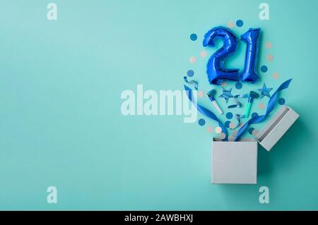 Numero 21 compleanno palloncino celebrazione scatola regalo lay piatto esplosione Foto Stock