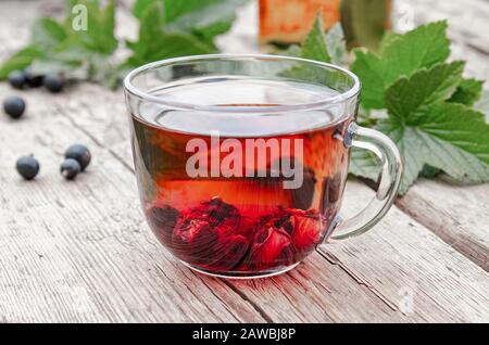 Vetro trasparente tè pentola con acqua calda tè nero su un tavolo di legno.  Chiudere verticale up shot Foto stock - Alamy