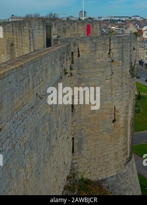 Vista su un enorme muro difensivo in pietra e torre presso la fortezza di Caen, Francia Foto Stock