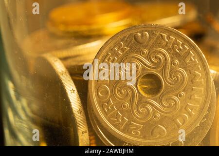 Monete di diversi paesi in vaso di vetro, monete metalliche di diverse denominazioni e di vari paesi, sfondo finanziario, corona danese Foto Stock