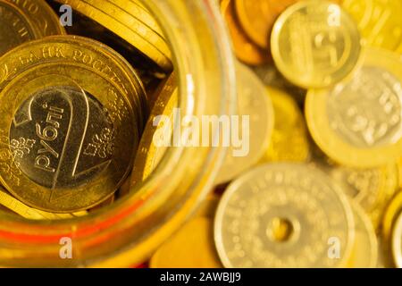 Monete di paesi diversi in un vaso di vetro. Molte monete metalliche di diverse denominazioni e di vari paesi. Contesto finanziario. Belorussiano Foto Stock