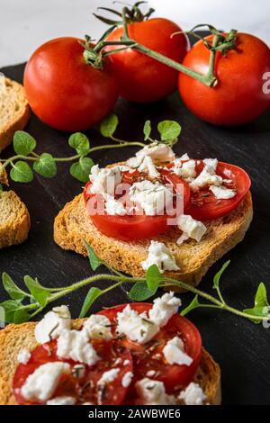 Piccoli toast con pomodori e formaggio Feta. Foto Stock