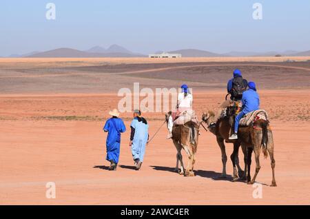 I turisti in un safari in cammello sono guidati da guide berbere in Marocco Nord Africa Foto Stock