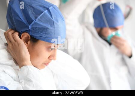 Wenzhou, Cina. 08th Feb, 2020. Maurizian Hosany Sumayyah (L) e suo marito pakistano Abdul Zahir Hamad indossare tute protettive prima di entrare in lavoro in un nuovo checkpoint di prevenzione e controllo del coronavirus di un'uscita autostradale a Wenzhou, nella provincia di Zhejiang della Cina orientale, 8 febbraio 2020. Pakistan Abdul Zahir Hamad e Mauriziano Hosany Sumayyah, una coppia sposata, entrambi lavorano come medici al PanHealth Medical Center di Wenzhou. Dallo scoppio del romanzo coronavirus, sono stati al servizio come volontari in un checkpoint di uscita autostradale a Wenzhou, controllando le informazioni di identità e di credito: Xinhua Foto Stock