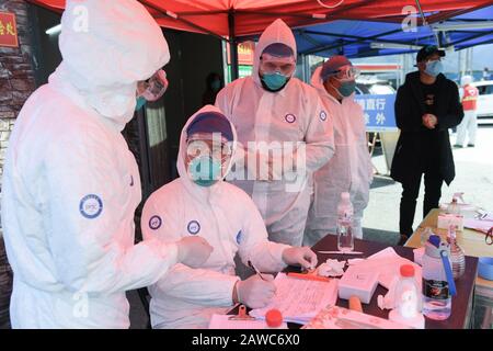 Wenzhou, Cina. 08th Feb, 2020. Pakistano Abdul Zahir Hamad (3rd L) e sua moglie Mauriziano Hosany Sumayyah (1st L) registrano le informazioni delle persone controllate in un nuovo checkpoint di prevenzione e controllo del coronavirus di un'uscita autostradale a Wenzhou, nella provincia di Zhejiang della Cina orientale, 8 febbraio 2020. Pakistan Abdul Zahir Hamad e Mauriziano Hosany Sumayyah, una coppia sposata, entrambi lavorano come medici al PanHealth Medical Center di Wenzhou. Dallo scoppio del romanzo coronavirus, sono stati al servizio come volontari in un checkpoint di uscita autostradale a Wenzhou, controllando le informazioni di identità e m Credit: Xinhua Foto Stock