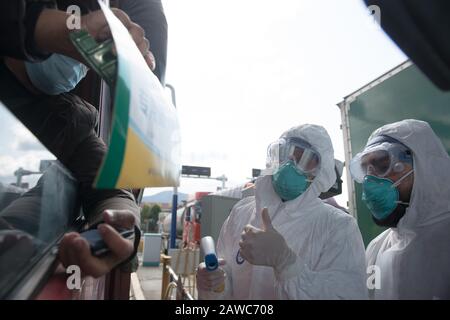 Wenzhou, Cina. 08th Feb, 2020. Pakistano Abdul Zahir Hamad (R) e sua moglie Mauriziano Hosany Sumayyah controllare le informazioni dell'automobile ad un nuovo punto di controllo di prevenzione e controllo del coronavirus di un'uscita di autostrada a Wenzhou, nella provincia di Zhejiang della Cina orientale, 8 febbraio 2020. Pakistan Abdul Zahir Hamad e Mauriziano Hosany Sumayyah, una coppia sposata, entrambi lavorano come medici al PanHealth Medical Center di Wenzhou. Dallo scoppio del romanzo coronavirus, sono stati al servizio come volontari ad un punto di controllo di uscita autostradale a Wenzhou, controllando le informazioni di identità e misurando il corpo temperatu credito: Xinhua Foto Stock