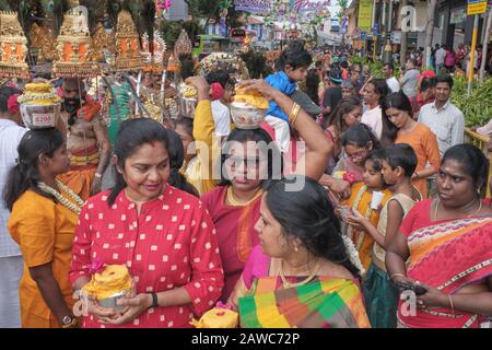 Per il festival indù di Thaipusam e come parte del rituale, un gruppo di donne indù sono simbolicamente portatori di pentole di latte; Little India, Singapore Foto Stock