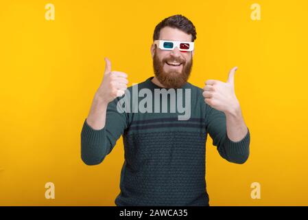 Foto di un uomo con i pollici che mostra e indossa occhiali 3D Foto Stock