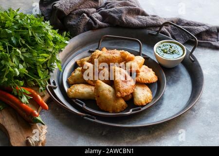 Empanadas de carne argentinas con chimichurri salsa Foto Stock