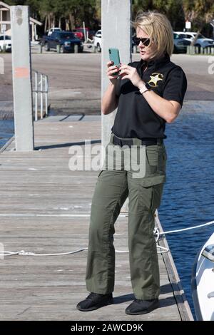 Trisha Kukuvka, Dipartimento di Martin County Sheriff, scatta una foto mentre sei su un molo presso la tasca del Manatee nel Sandsprit Park a Port Salerno, Florida, Stati Uniti. Foto Stock