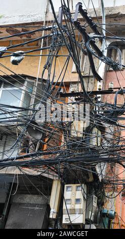 Elettricità confusa impigliata, cavi per telecomunicazioni, cavi su pali in Hanoi, Vietnam Foto Stock
