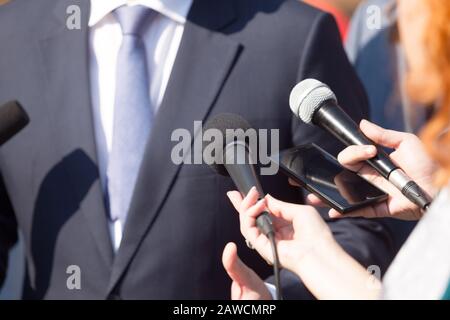 Giornalisti che fanno l'intervista di stampa con politico o la persona di affari Foto Stock