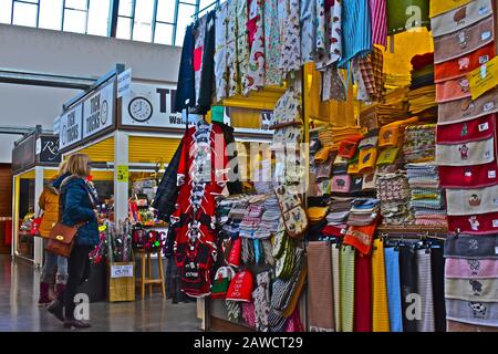 Mercato interno "nuovo" di Carmarthen. Gli acquirenti che esplorano bancarelle colorate. Articoli mulit-colorati per la vendita Foto Stock