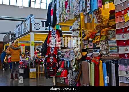 Mercato interno "nuovo" di Carmarthen. Gli acquirenti che esplorano bancarelle colorate. Articoli mulit-colorati per la vendita Foto Stock