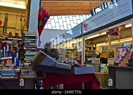 Mercato interno "nuovo" di Carmarthen. Gli acquirenti che esplorano bancarelle colorate. Foto Stock