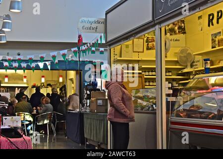 Mercato interno "nuovo" di Carmarthen. Gli acquirenti che esplorano bancarelle colorate. Foto Stock