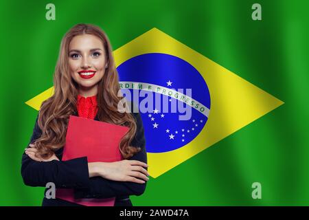 Il Brasile concetto con carino donna studente contro la bandiera brasiliana sfondo. Viaggio in Brasile e imparare la lingua portoghese Foto Stock