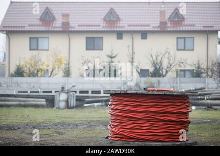 Avvolgicavo in legno all'aperto durante una giornata fredda di pioggia. Foto Stock