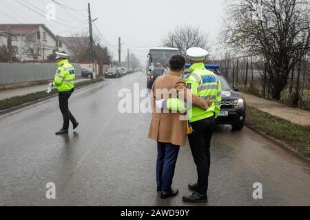 Popesti Leordeni, Romania - 20 dicembre 2019: Profondità di campo poco profonda (fuoco selettivo) immagine con un uomo che scatta una foto insieme ad un poliziotto. Foto Stock