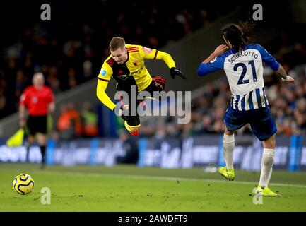 Gerard Deulofeu di Watford (a sinistra) prende un tumble dopo una sfida da Brighton e Hove Albion's Ezequiel Schelotto (a destra) durante la partita della Premier League all'AMEX Stadium, Brighton. Foto Stock