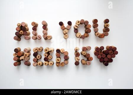 Tappi di vino TUTTO CIÒ DI CUI HAI BISOGNO È testo D'AMORE con forma a cuore isolato su sfondo bianco Foto Stock