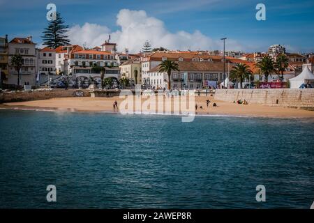 La spiaggia di Praia da Ribeira è la spiaggia principale di Cascais, che si affaccia sulla piazza centrale della città e si affaccia sul porto peschereccio. Foto Stock