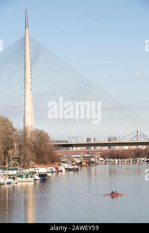 Belgrado, Serbia - 2 febbraio 2020: Giovani in kayak nel fiume Sava armlet, sotto i ponti della città di Ada, in una soleggiata giornata invernale Foto Stock