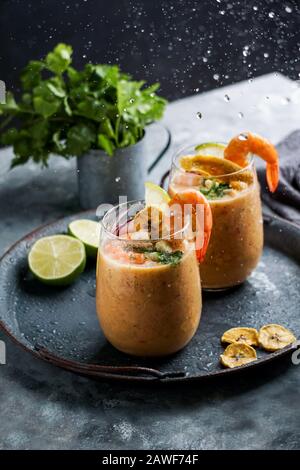 Leche de tigre, peruviano, Ecuador, cibo latino-americano, cocktail di pesce crudo ceviche con lime, aji limon e coriandolo. Cibo tradizionale peruviano con s Foto Stock