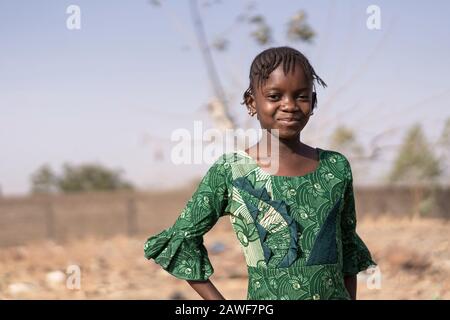 Bellezza africana in piedi Orgogliosamente nella savana del Mali meridionale con sorriso carino Foto Stock