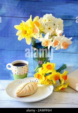 La colazione era ancora in vita, con una pasta fresca di mele, caffè nero e daffodils giallo brillante e fiori di jonquil Foto Stock