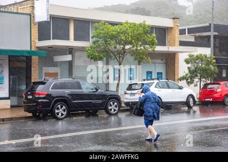 Forti tempeste e pesanti battitori di pioggia Sydney nel febbraio 2020, la gente del posto ad Avalon Beach Sydney che porta ombrelloni in una giornata di estati bagnate, Australia Foto Stock