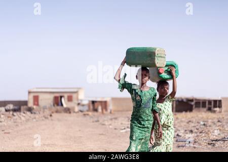 Lavorare African Ethnicity Schoolgirl Raccogliere Acqua Fresca per mancanza di acqua simbolo Foto Stock