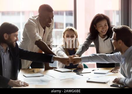 I dipendenti sono felici e diversificati, che si uniscono ai pugni, celebrando il successo Foto Stock