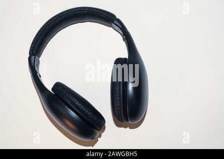 Cuffie nere su sfondo beige. Auricolari wireless Foto Stock