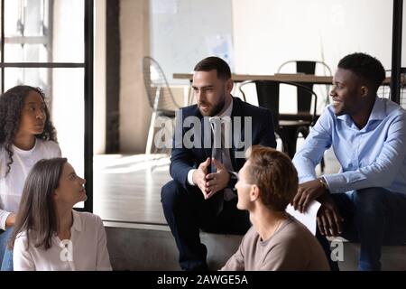 Diversi compagni di chat durante la pausa godersi una conversazione informale amichevole Foto Stock