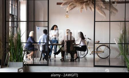 Diversi imprenditori che negoziano durante la riunione di gruppo guidata da donne d'affari africane Foto Stock