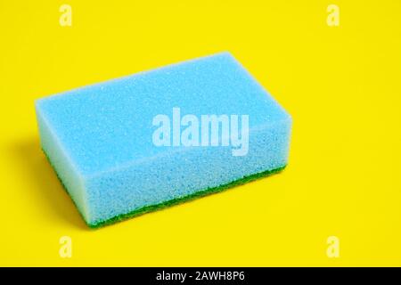 Spugna blu per lavare piatti su fondo giallo. Foto Stock