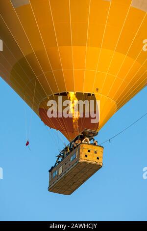 I bruciatori sono applicati in un colorato pallone ad aria calda mentre galleggia lungo una valle vicino Goreme nella regione della Cappadocia della Turchia. Foto Stock