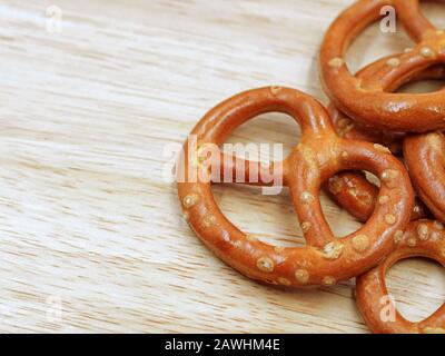 primo piano di cracker croccante salato mini pretzel su sfondo di tavolo di legno con spazio di copia Foto Stock