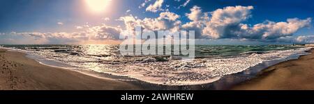 Splendida vista panoramica dalla spiaggia sabbiosa all'orizzonte, con luci spettacolari sul mare mosso e meraviglioso cielo blu scuro con scenica cumulonimbus nuvole a Foto Stock