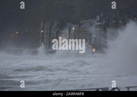 Aberystwyth, Galles, Regno Unito. 9th febbraio 2020 . Gale forza venti dalla tempesta Ciara una tempesta chiamata dell'inverno, combinato con il picco della marea alta creare enormi onde di ancoraggio contro la passeggiata e le difese del mare a Aberystwyth. Sono in vigore avvertimenti meteo gialli e ambra con il rischio di danni causati dal vento e da onde potenti lungo le zone costiere. Credito: Mike davies/Alamy Live News Foto Stock